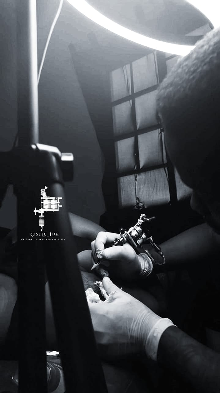 Artist tattooing in the Rustle Ink studio